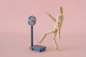 体重計に乗ろうとするデッサン人形